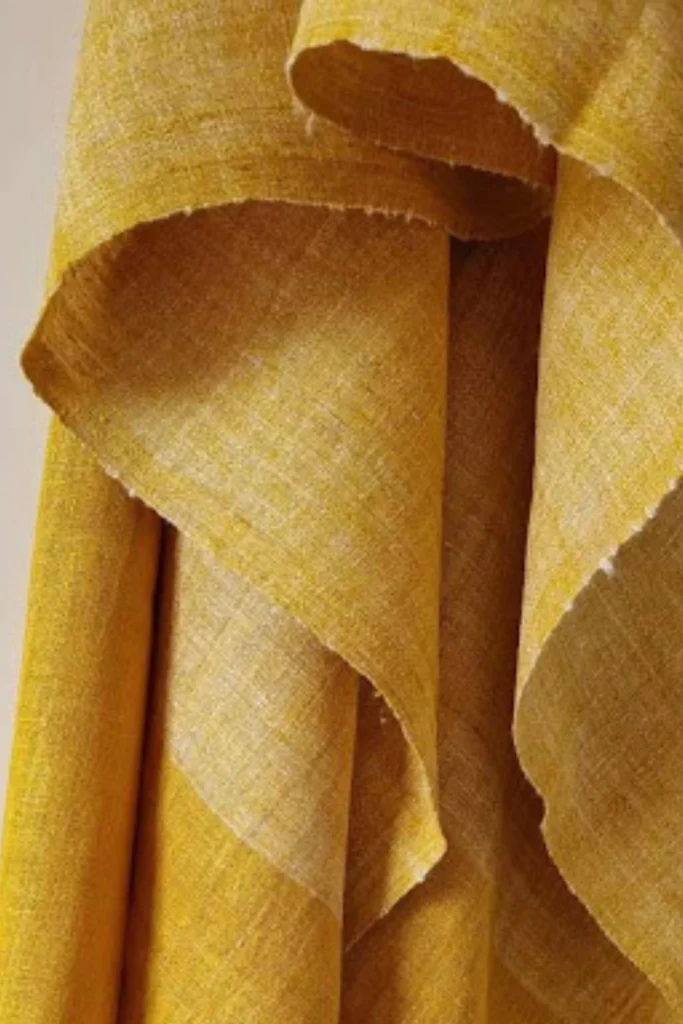 Close-up view of naturally dyed turmeric yellow Ahimsa Eri silk fabric showing handwoven texture and soft folds.