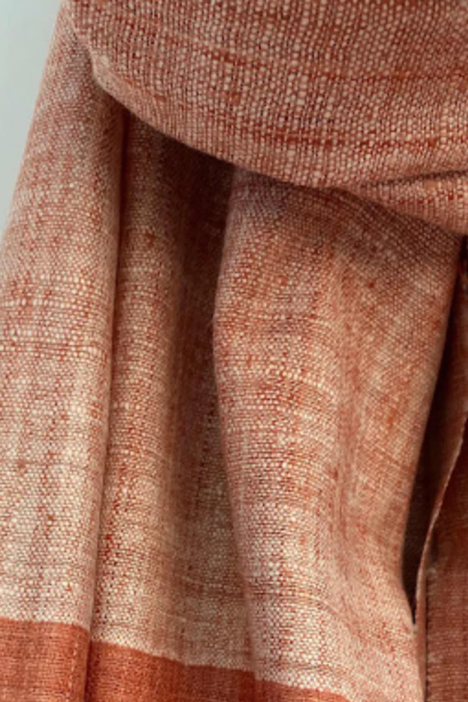 Close-up of handwoven Ahimsa Eri silk stole dyed with Indian madder, featuring earthy terracotta tones and natural woven texture.