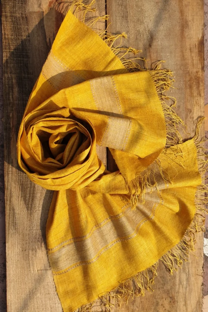 Handwoven turmeric-dyed Ahimsa Eri silk stole with delicate fringes and natural woven texture by Yarn Glory.